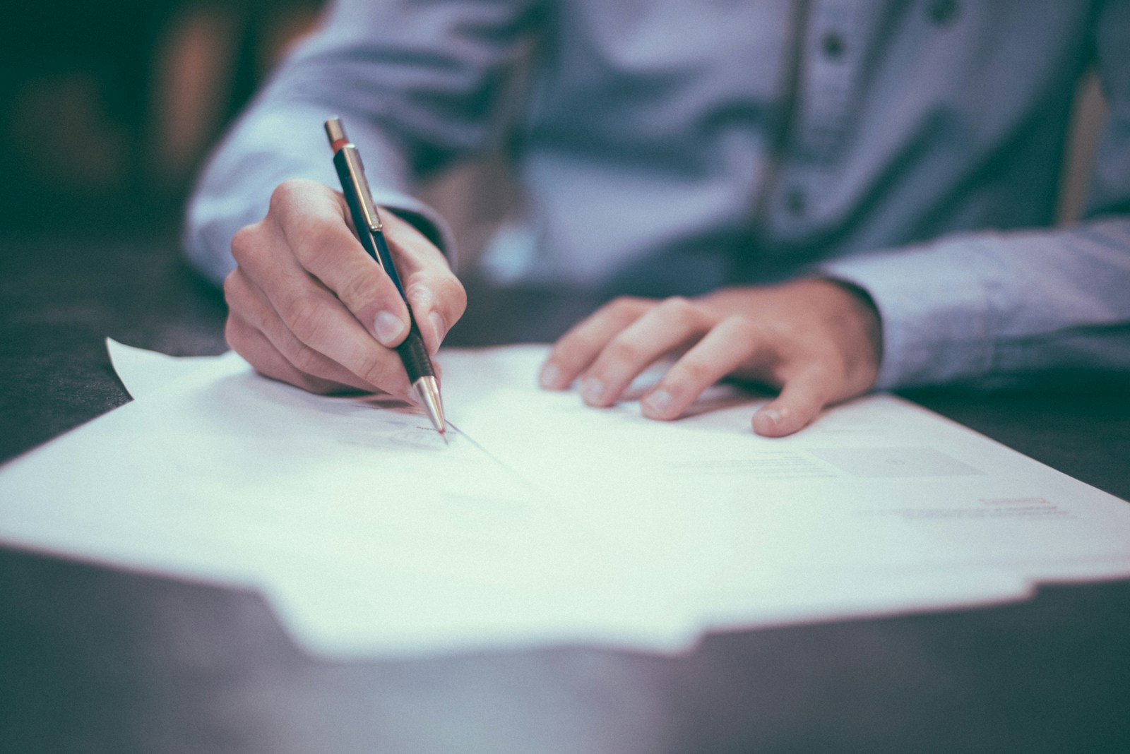 man writing on general liability insurance paper